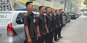 Petugas keamanan berdiri di samping mobil patroli