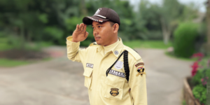 Satpam memberi hormat, menunjukkan profesionalisme dan kedisiplinan.